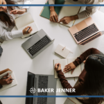 Four people sit around a table with laptops and notebooks, taking notes and having a discussion. The image includes the Baker Jenner logo at the bottom center.